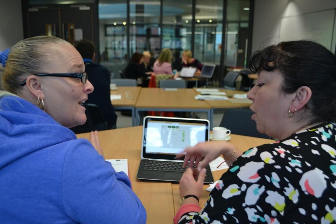 Two teachers discussing FractionsLab at a Mathematics Specialist Teachers workshop